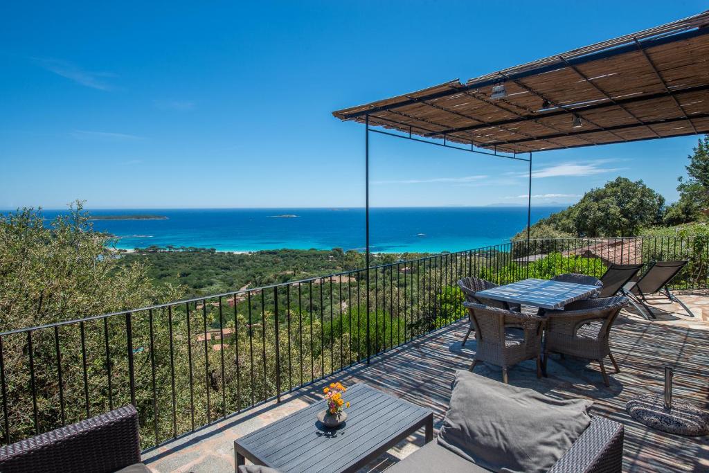 a patio with a table and chairs and the ocean at Résidence Belvedere de Palombaggia in Porto-Vecchio