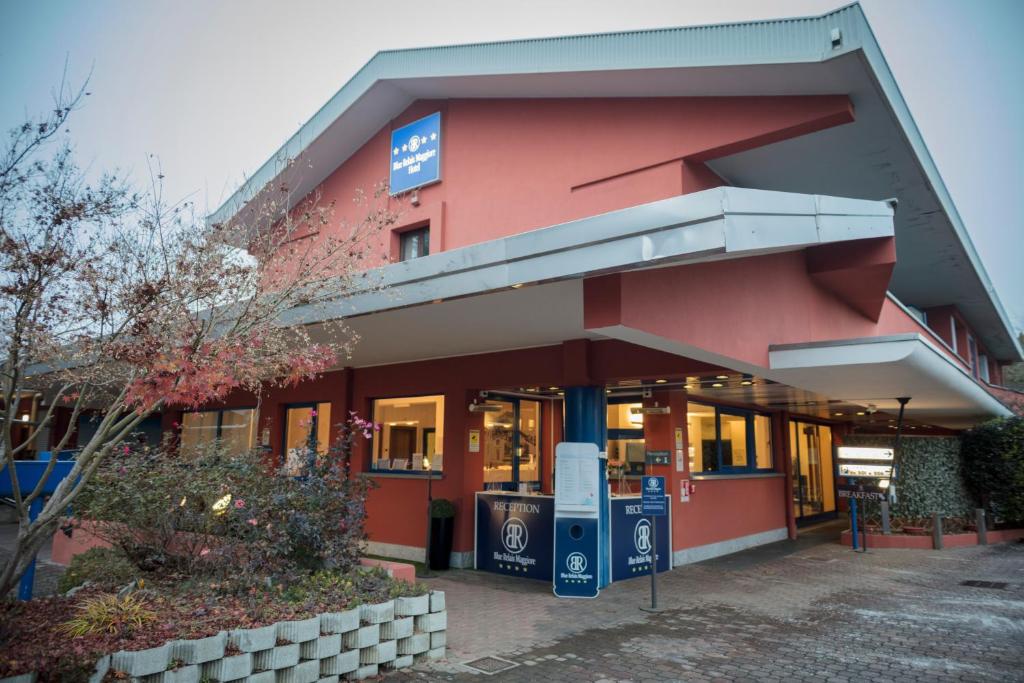 un negozio di fronte a un edificio rosso di Blue Relais Maggiore a Castelletto sopra Ticino