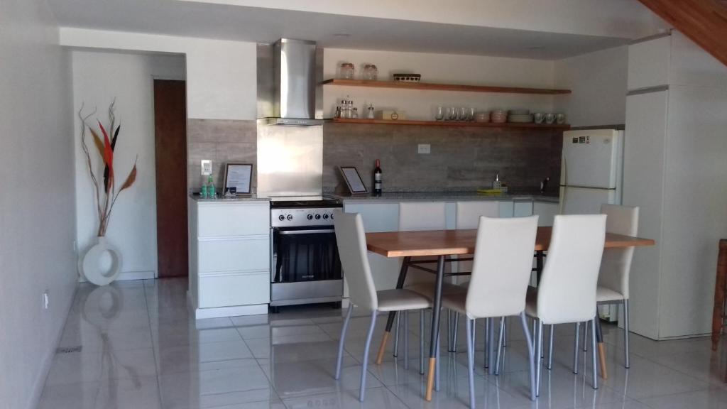 eine Küche mit einem Holztisch und weißen Geräten in der Unterkunft Dos Lunas in Rosario