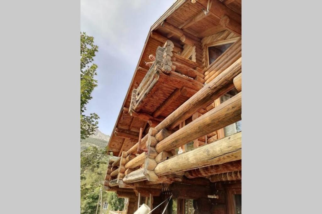 a large wooden house with a roof at Le ZEN in Allos