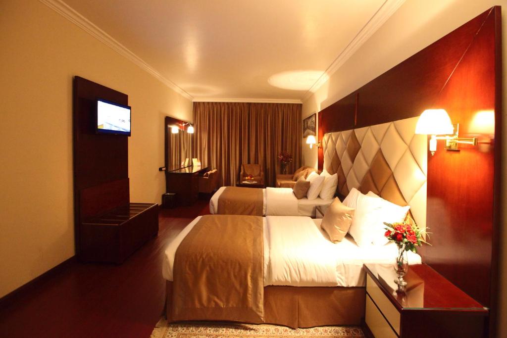 a hotel room with two beds and a television at Gulf Inn Hotel Deira Formerly City Star Hotel in Dubai