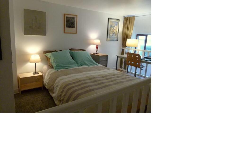 ein Schlafzimmer mit einem Bett, einem Tisch und einem Stuhl in der Unterkunft Studio Fabert in Paris