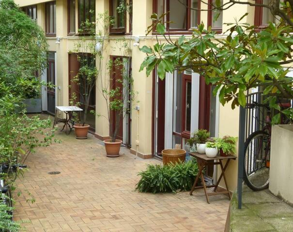 einen Innenhof mit Topfpflanzen vor einem Gebäude in der Unterkunft Studio Fabert in Paris
