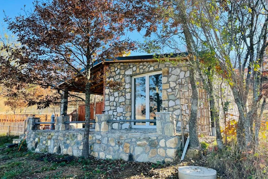 a small stone house with a window and a stone wall at Villa SEMI in Gjilan
