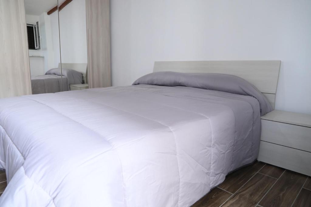 a white bed with a blue blanket on top of it at La Bellavista Mola di Bari in Mola di Bari
