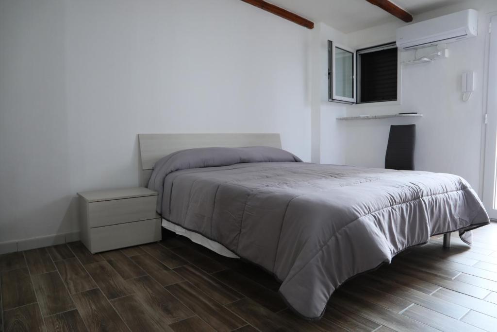 a white bedroom with a bed and a night stand at La Bellavista Mola di Bari in Mola di Bari