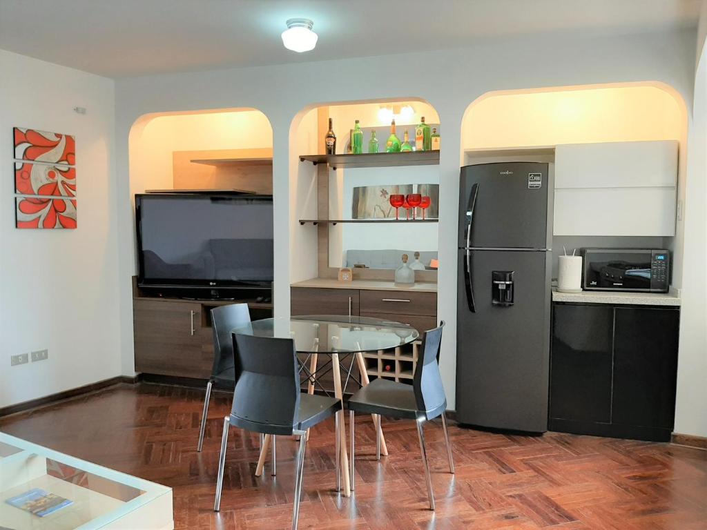 une cuisine avec une table et un réfrigérateur dans l'établissement Miraflores Kennedy's Park Apartment, à Lima