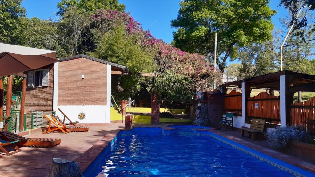 a swimming pool in a yard with a house at Los Arboles in Villa Urquiza