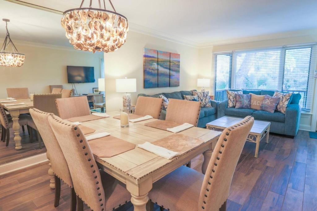 a dining room with a table and a couch at Sea La Vie in Kiawah Island