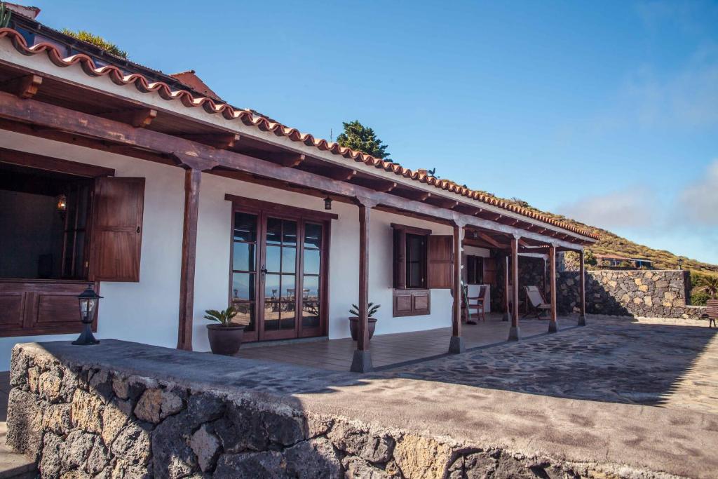 un edificio con una pared de piedra delante de él en Villas Los Torres I en Fuencaliente de la Palma