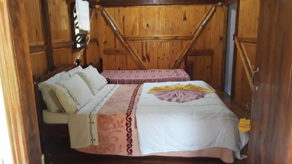 a bedroom with two beds with wooden walls at Sitio Pinhal in Silveiras