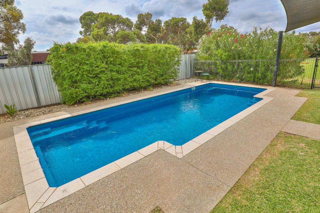 a swimming pool with blue water in a yard at Robinvale Bridge Motel in Robinvale 