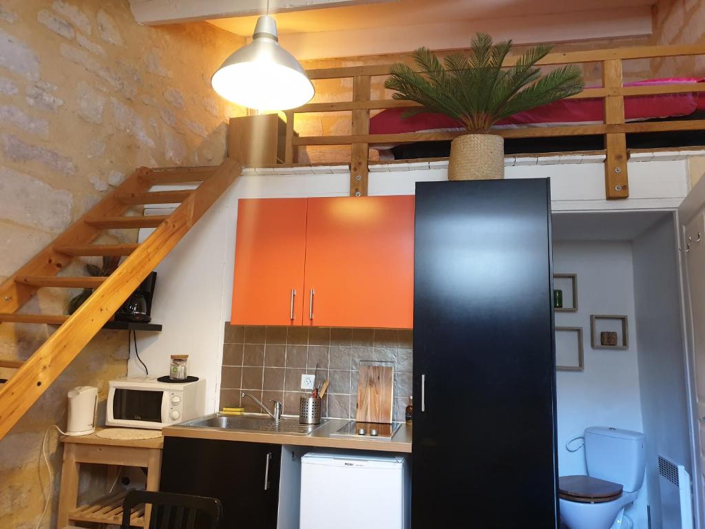 een keuken met een zwarte koelkast in de kamer bij Joli petit studio au cœur d'Uzès in Uzès