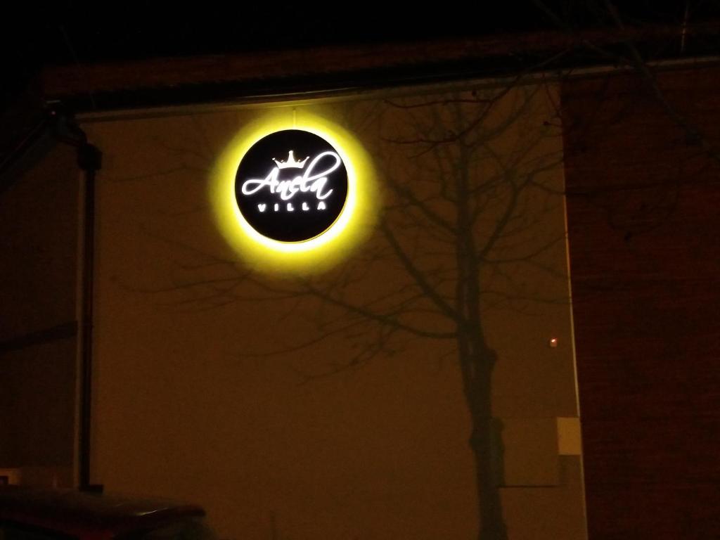 una señal de neón en el lateral de un edificio por la noche en Villa Anela en Pasuljište