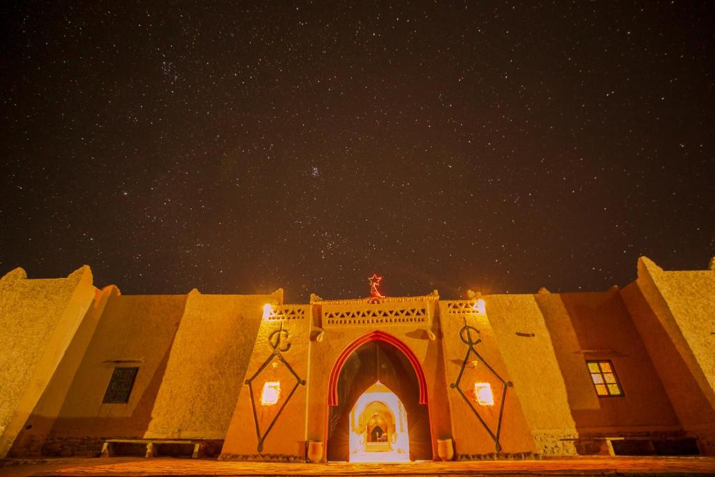 un edificio de noche con un cielo estrellado en Takojt en Merzouga