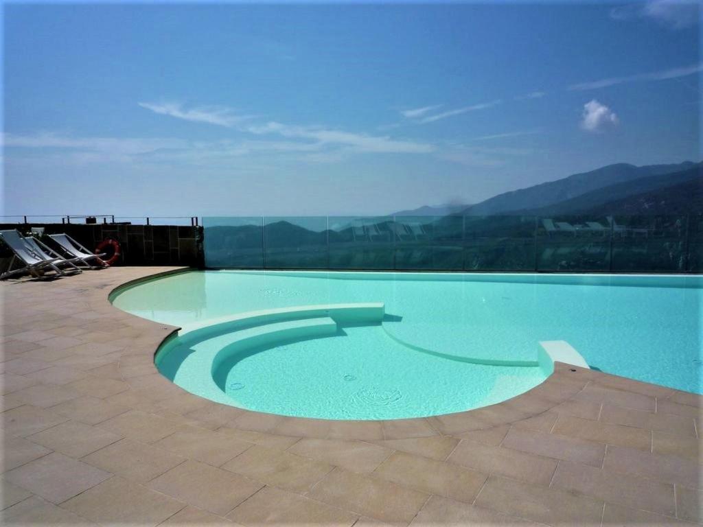 - une piscine au-dessus d'un bâtiment avec des montagnes en arrière-plan dans l'établissement Belvilla by OYO Vista Gentile, à Magliolo