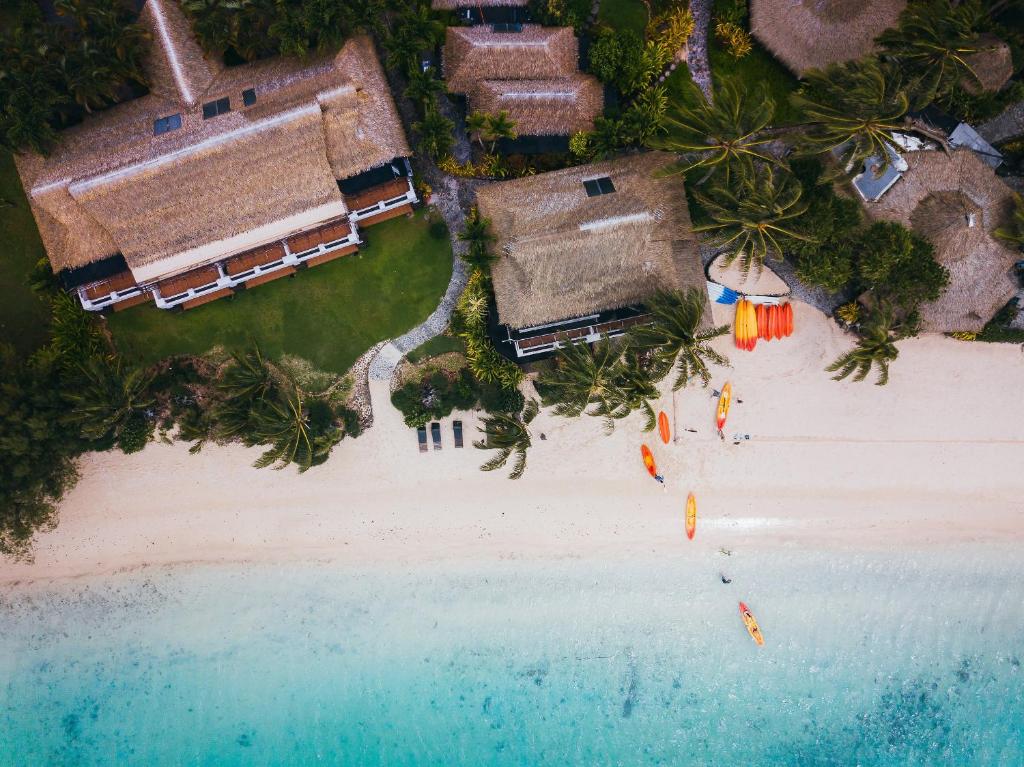 an aerial view of a beach with houses and umbrellas at Pacific Resort Rarotonga in Rarotonga