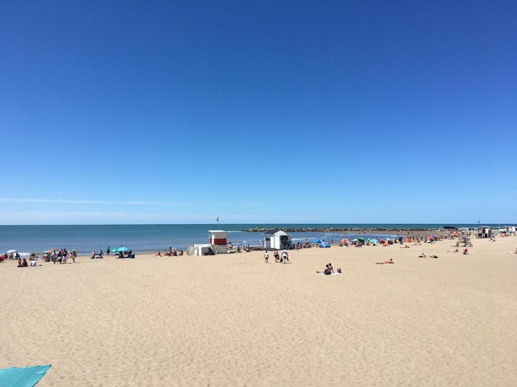 un grupo de personas en una playa cerca del océano en Departamento en Mar Del Plata en Mar del Plata