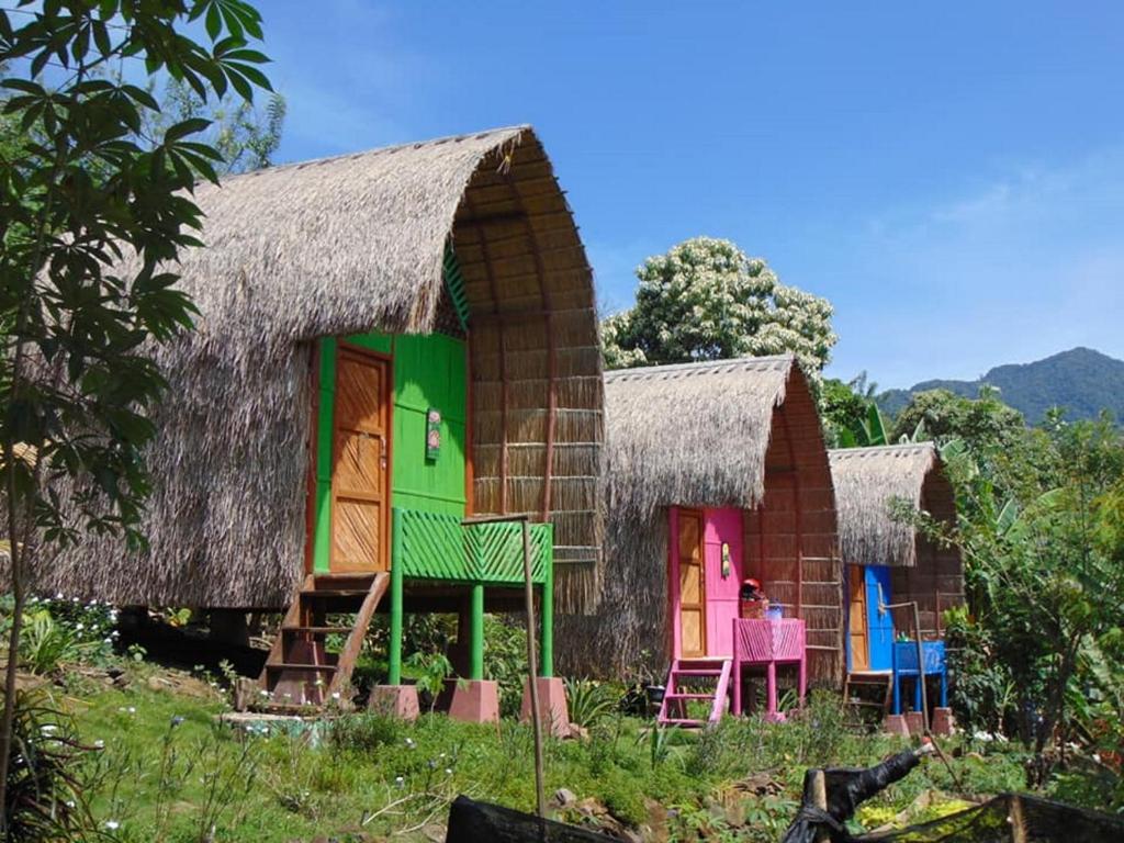 a group of houses with colorful doors and chairs at Sten Lodge eco Homestay in Labuan Bajo
