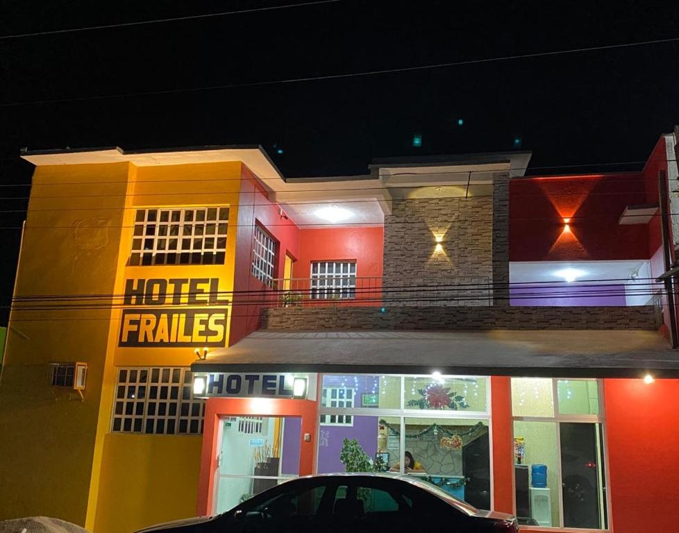 a hotel with a neon sign on the side of a building at Hotel Frailes in Arriaga