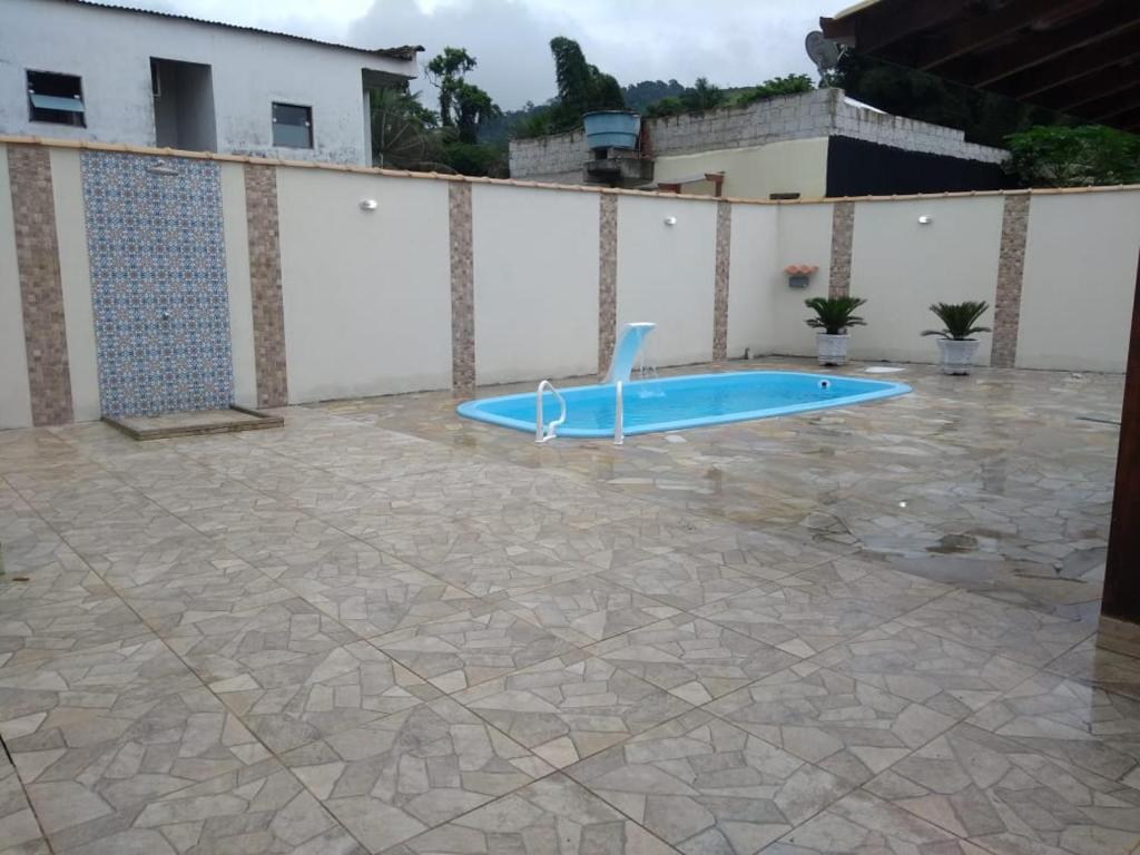 a swimming pool in a courtyard with a blue swimming pooliterator at Casa com Piscina para temporada em Paraty - Casa Nova e Aconchegante in Paraty