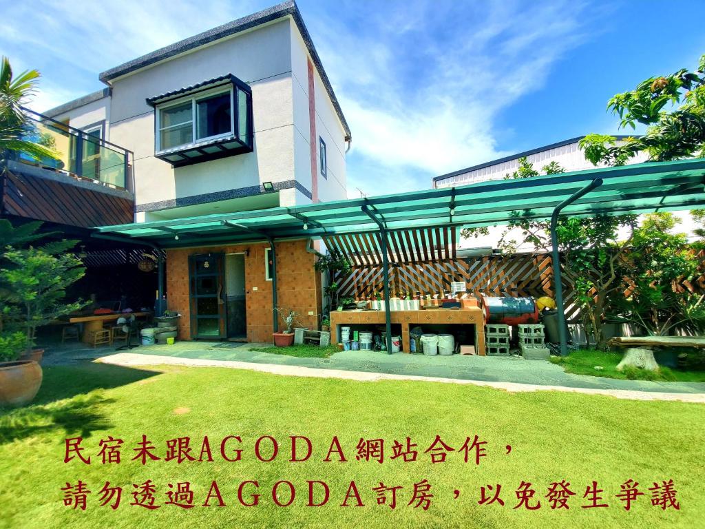 a house with awning in a yard at Stone Home Bed and Breakfast in Taitung City