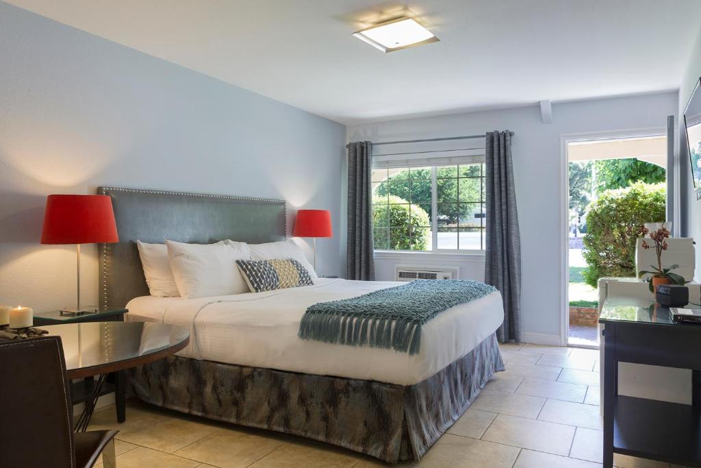 a bedroom with a bed and a desk and windows at The Lodge at Blue Lakes in Upper Lake