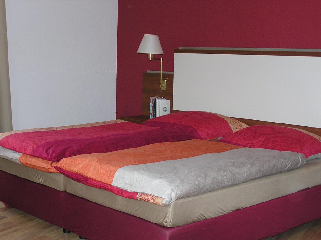 a bedroom with two beds with red walls at Auerbachs Keller in Plauen