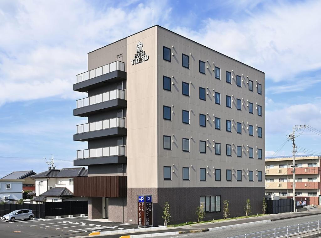 un edificio alto con una macchina parcheggiata di fronte di Hotel Trend Suzuka a Suzuka