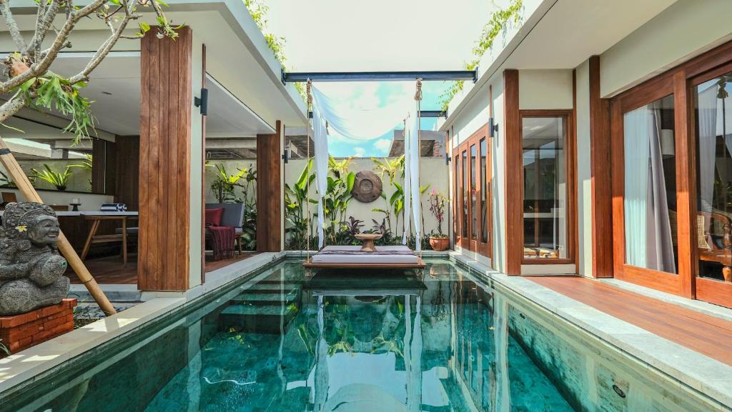 una piscina cubierta en una casa con una casa en Sampatti Villas, en Seminyak