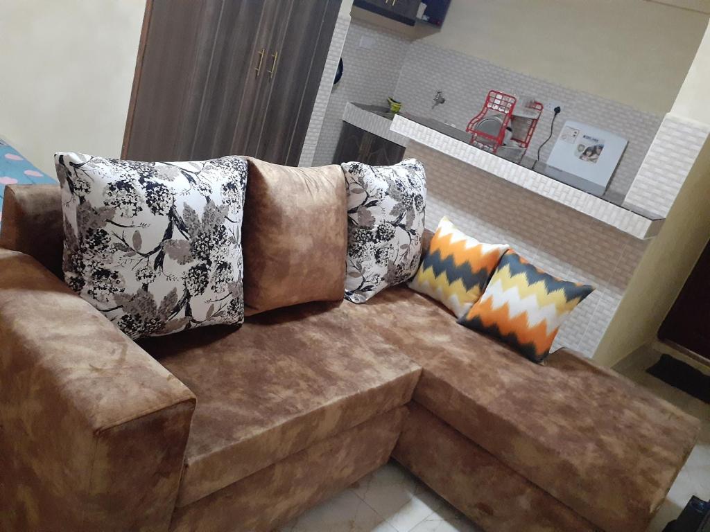 Athi River的住宿－Royal studio in Kitengela，客厅里配有带枕头的棕色沙发