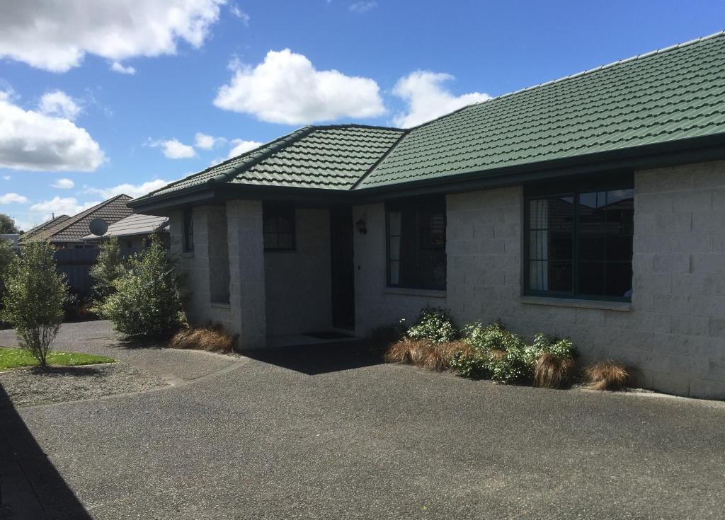 a house with a green roof and a driveway at Haven On Carroll in Palmerston North