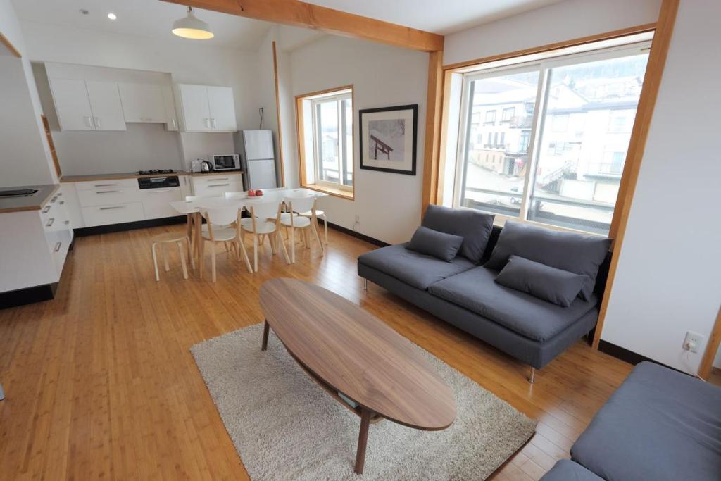 a living room with a couch and a table at Nozawa Central in Nozawa Onsen