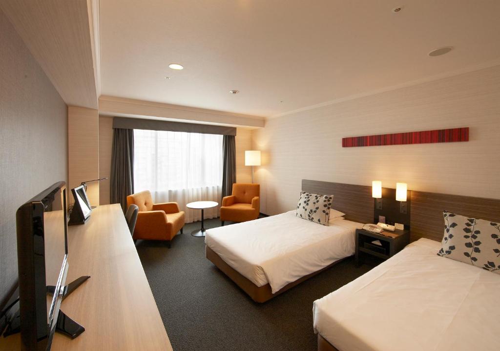 Postel nebo postele na pokoji v ubytování Nagoya Tokyu Hotel