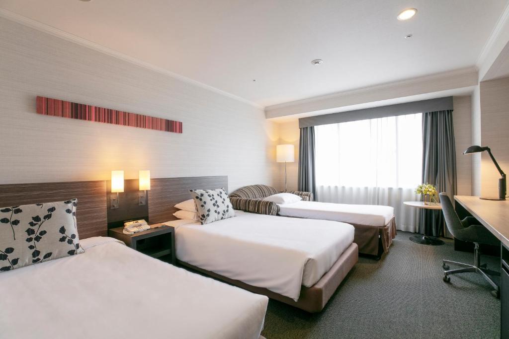 Postel nebo postele na pokoji v ubytování Nagoya Tokyu Hotel