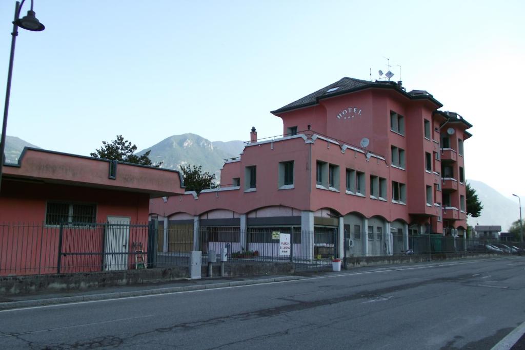 a red building on the side of a street at Hotel Total in Pisogne