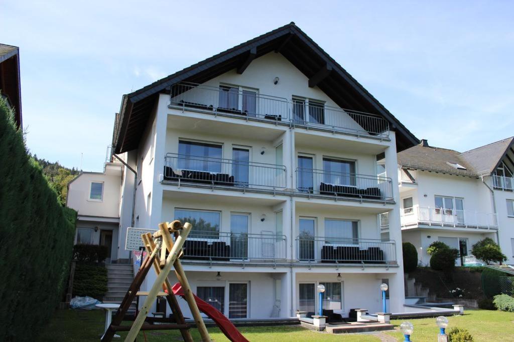 - un grand bâtiment blanc avec une aire de jeux en face dans l'établissement Ferienwohnung am Hofgarten, à Langenfeld