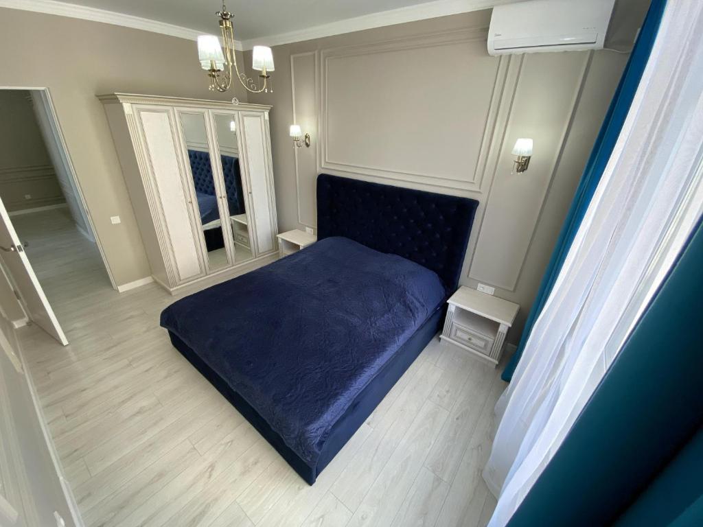 a bedroom with a bed with a blue blanket at ЖК ‘ZAMAN’ in Atyrau