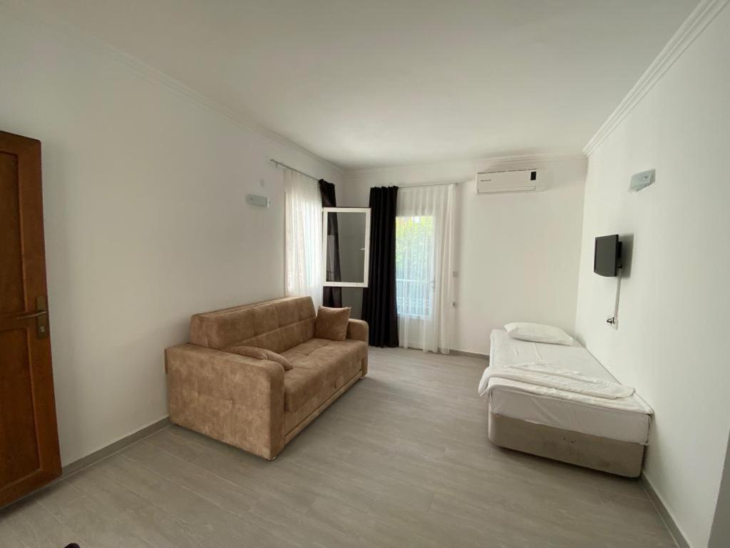 salon z kanapą i łóżkiem w obiekcie Manolya Hotel w Bodrum