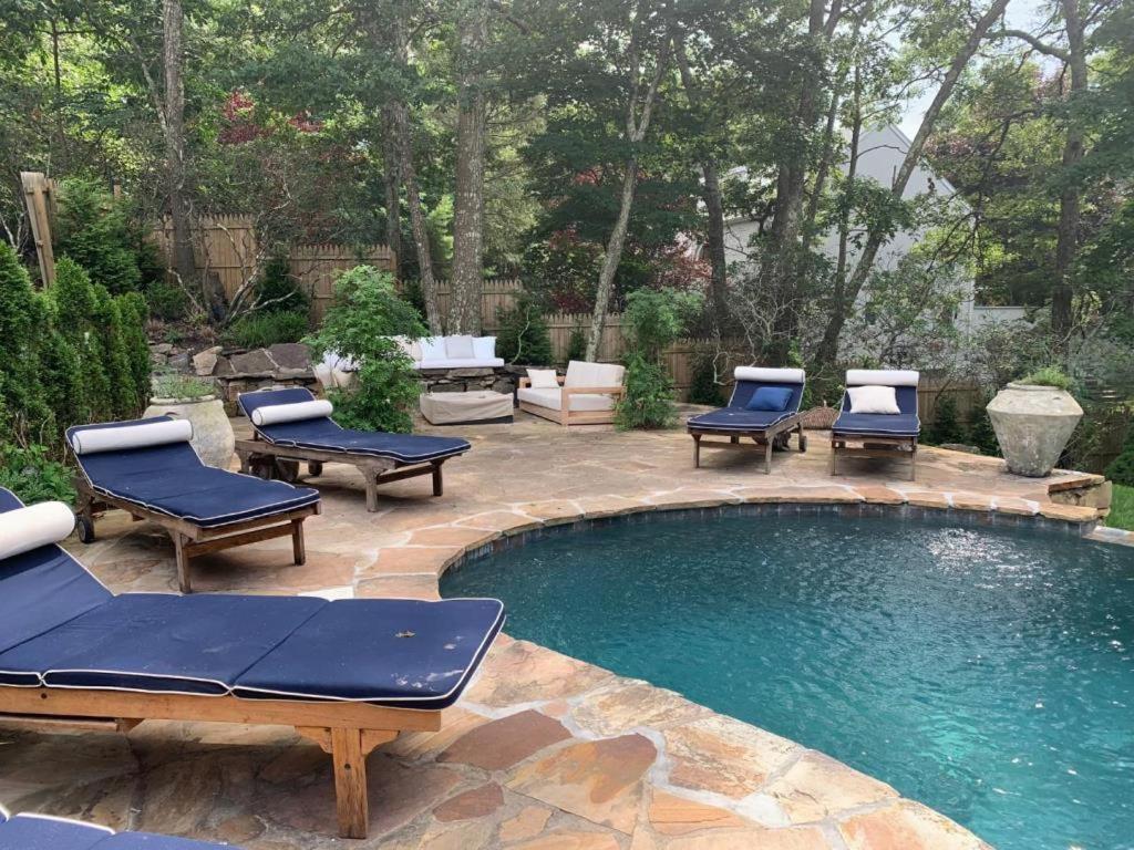 una piscina con tumbonas y un patio en Villa Zainip - Luxury with pool, en Sag Harbor