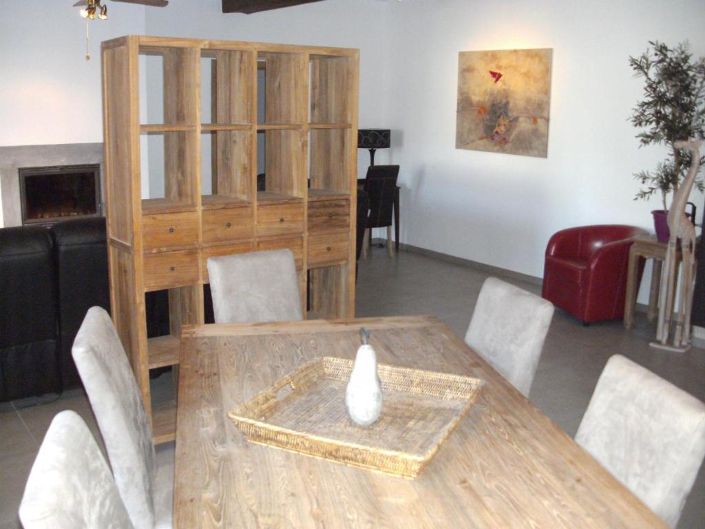 uma sala de jantar com uma mesa de madeira e cadeiras em La Ferme des Oliviers em Bende