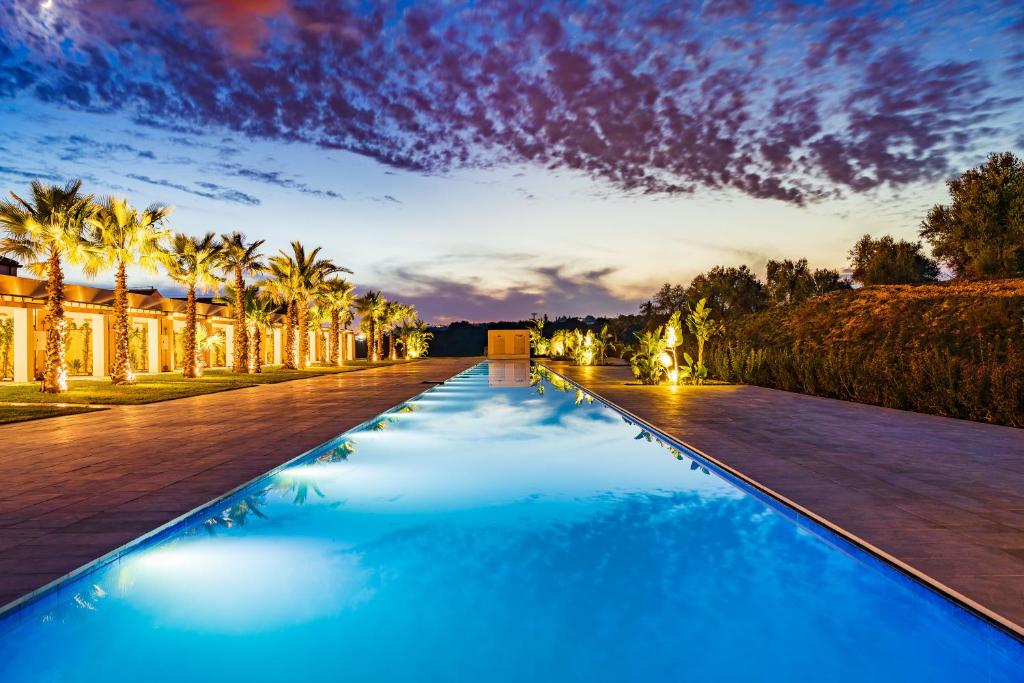 una piscina con acqua blu di fronte a un edificio di Il San Corrado di Noto a Noto