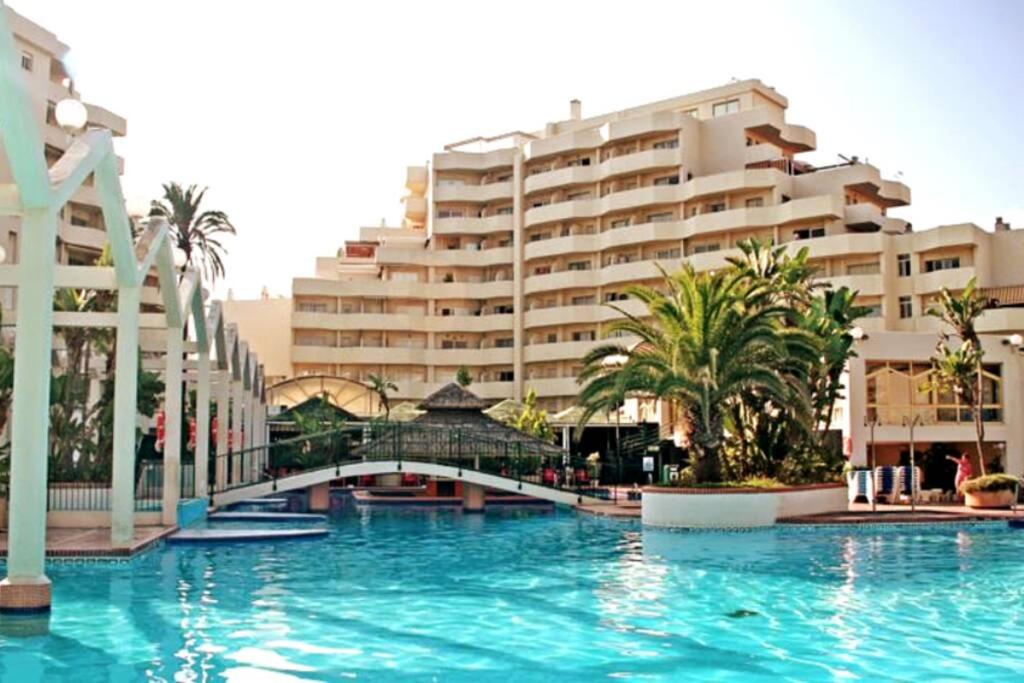 une grande piscine en face d'un grand bâtiment dans l'établissement Precioso apartamento frente al mar Benalbeach, à Benalmádena