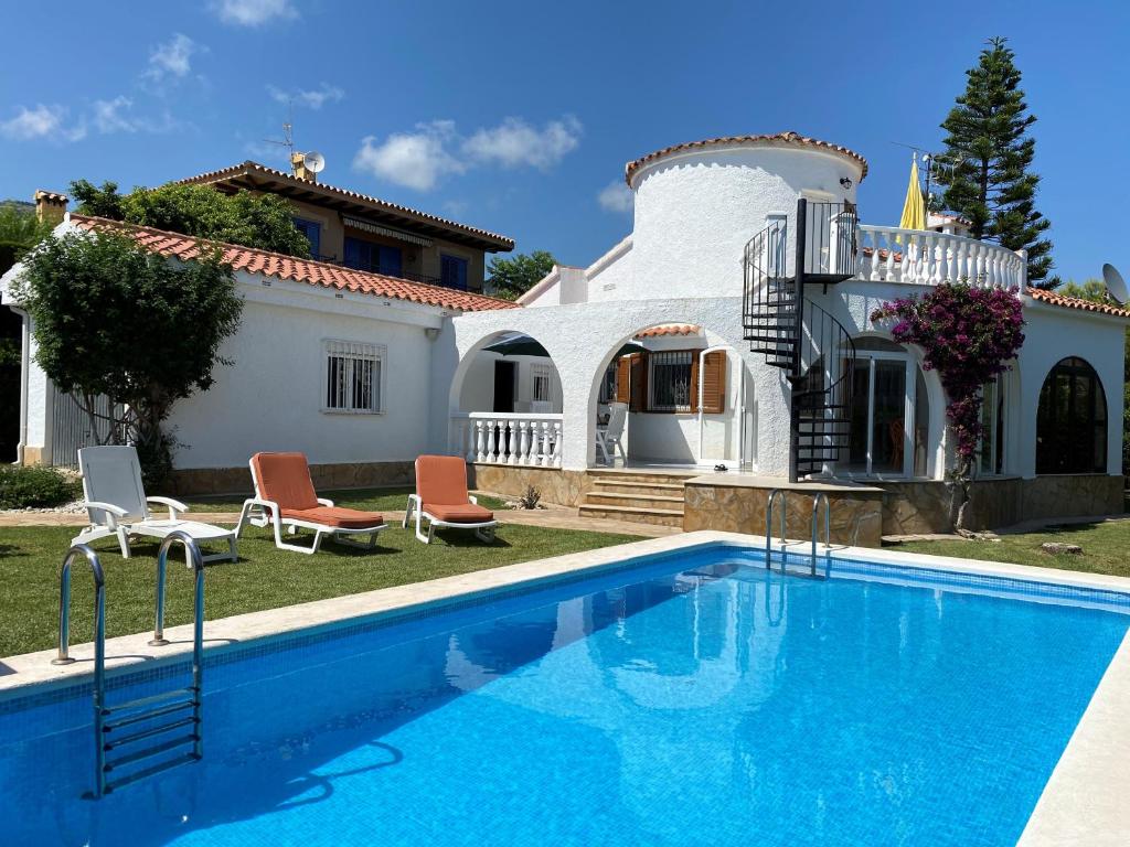 a villa with a swimming pool in front of a house at Villa Cala Blanca in Alcossebre