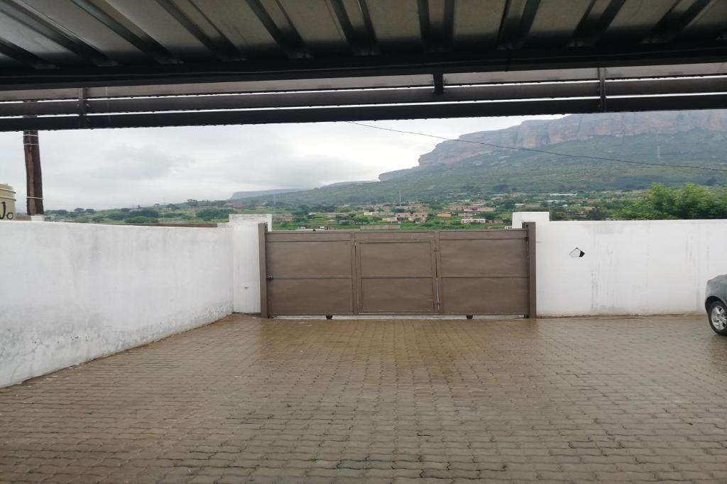 a large garage with a large wooden garage door at Maluti Backpackers in Phuthaditjhaba