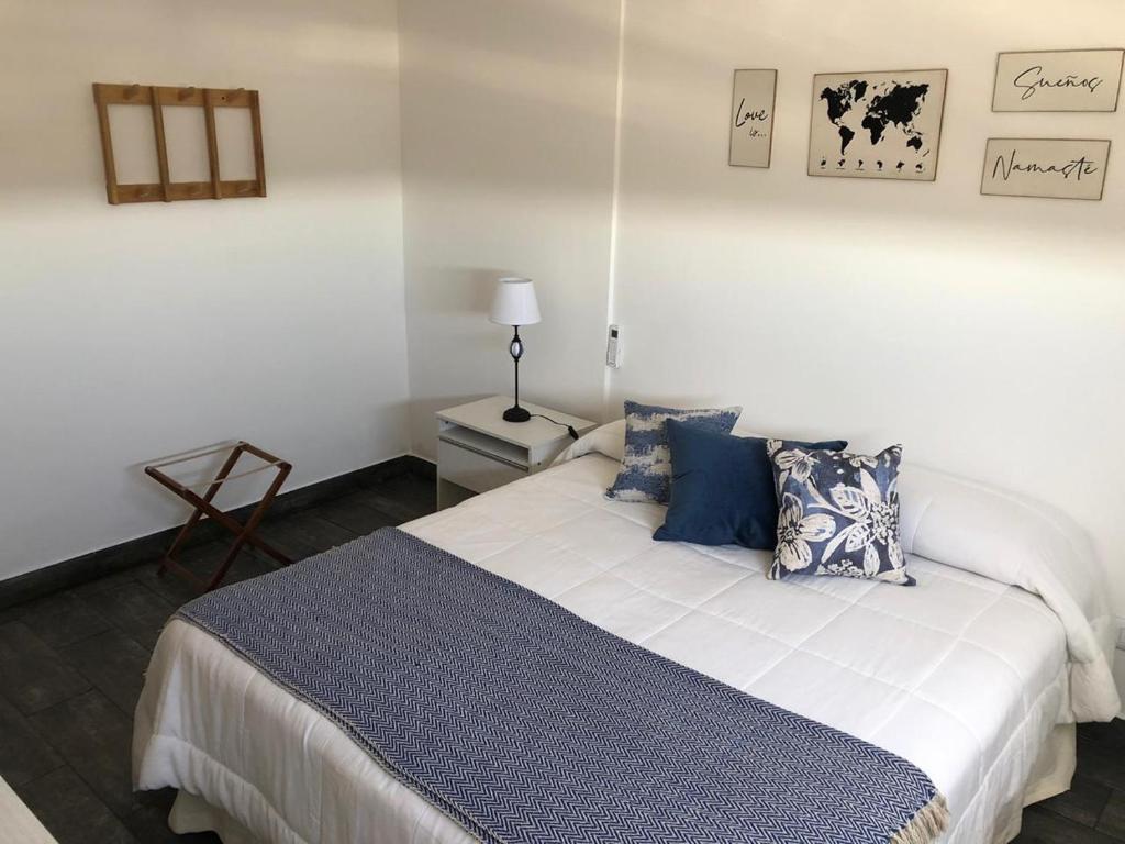 a bedroom with a bed with blue and white pillows at Namaste in Paraná