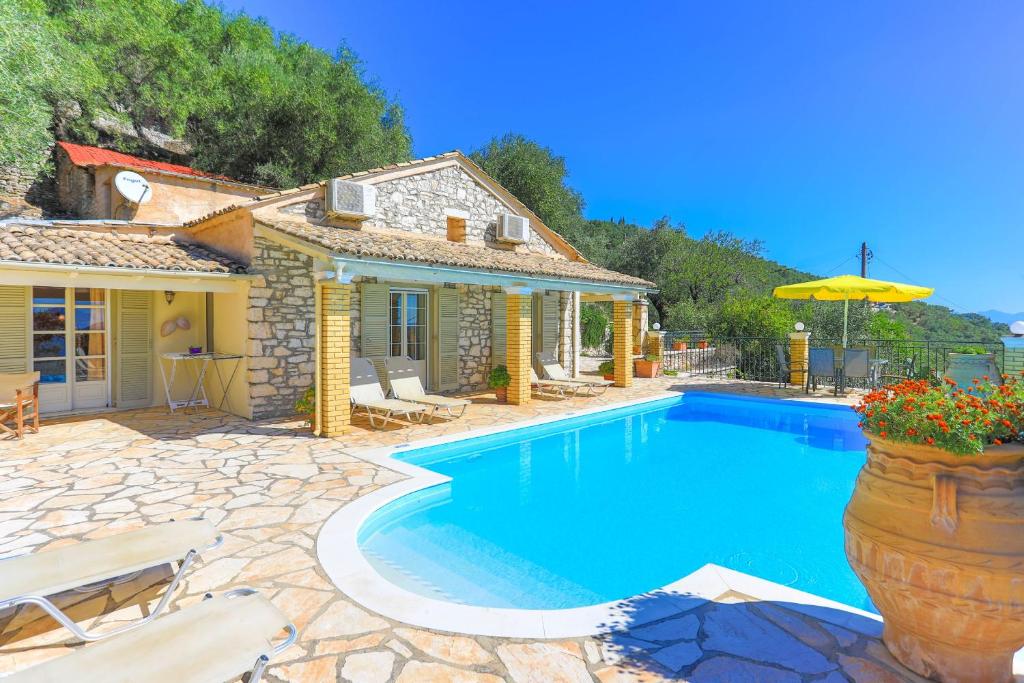 a villa with a swimming pool and a house at Villa Kefalaki in Katávolos