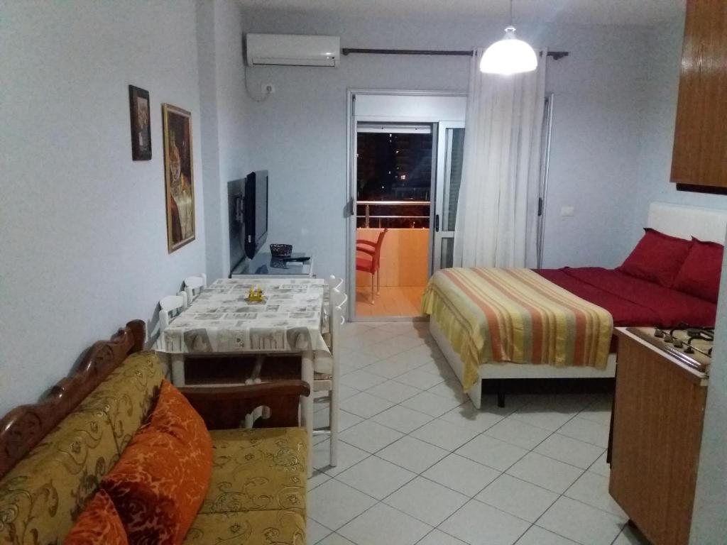 a room with a table and a bed and a kitchen at CHEAP AND COMFORTABLE APARTMENT AT SEASIDE in Vlorë