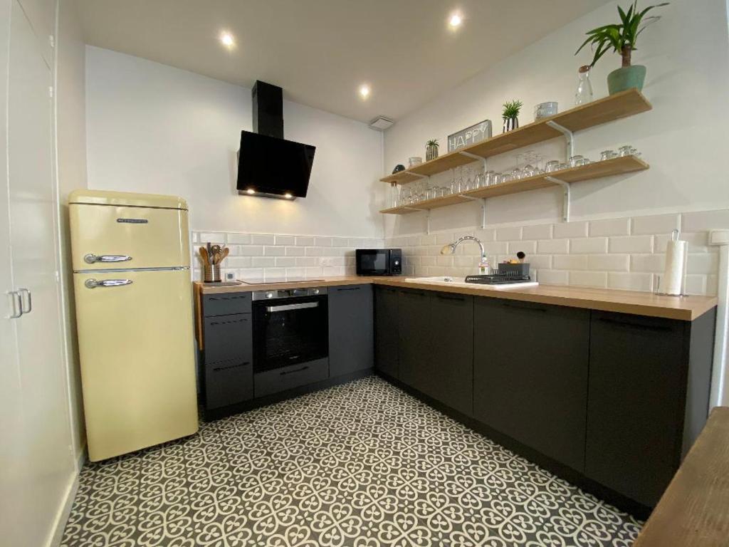 a kitchen with a refrigerator and a counter top at Superbe T2 de 45m² en hyper centre in La Rochelle