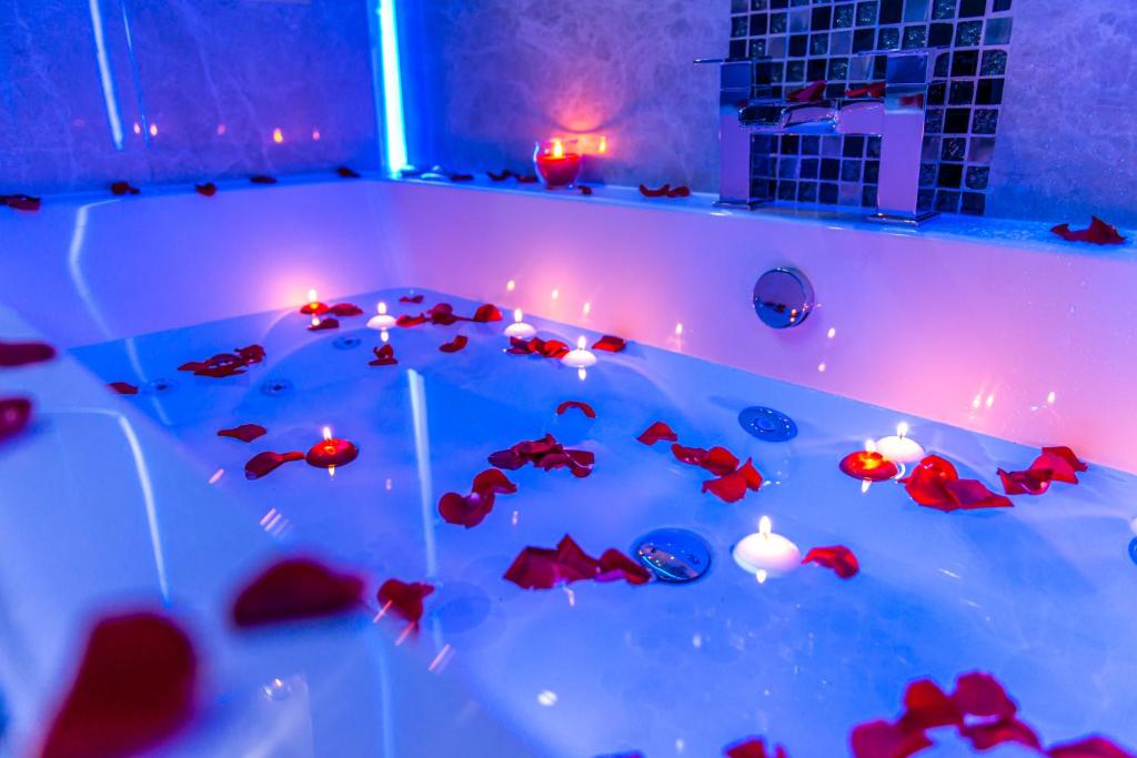 a bath tub filled with christmas lights and red fish at Velmora Suites in Huddersfield